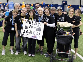 James Geddes, second from left in front, with his family and friends at the Canadian Cancer Society's Relay for Life in Kingston, Ont. on Saturday June 6, 2015. Geddes has beaten testicular and bladder cancer in the past five years. His team raised over $5,000 for cancer research. Steph Crosier/Kingston Whig-Standard/Postmedia Network