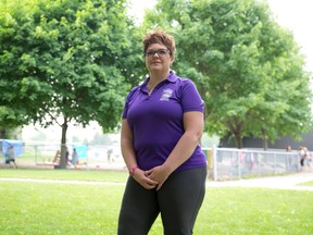 Shannon Simmons stands near the Arthur Ford Public School kindergarten playground at the Viscount Road elementary school in London. Simmons, along with a group of fellow parents, have been working for two years to raise the $18,000 needed to install play equipment in the empty play area.  (CRAIG GLOVER, The London Free Press)