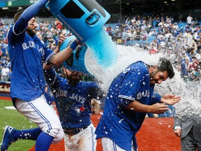 Chris Colabello of the Toronto Blue Jays is doused by Kevin Pillar and Russell Martin after driving in the winning runs in a 7-6 victory over the Houston Astros on June 7, 2015 at the Rogers Centre in Toronto. (STAN BEHAL/Toronto Sun)