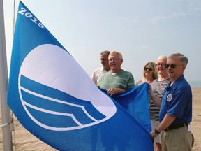 Central Elgin councillors Dennis Crevits, left, Harold Winkworth and Fiona Roberts raise their Blue Flag with Deupty Mayor Sally Martyn and Mayor David Marr at Port Stanley Main Beach on Friday morning. The Blue Flag is an international distinction awarded to beaches that meet strict water quality, environmental and management criteria.