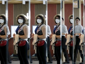 A tourist wearing a mask to prevent contracting Middle East Respiratory Syndrome (MERS), is reflected on mirrors in Seoul, South Korea, June 8, 2015. (REUTERS/Kim Hong-Ji)