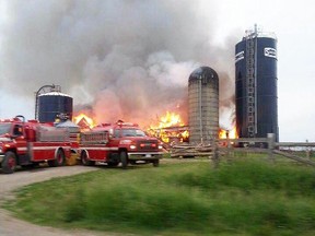 Firefighters battle a massive barn fire on Maple Grove Road in this photo taken by a passerby with a cellphone on Sunday, June 7, 2015 near Gananoque, Ont. (SUBMITTED PHOTO)