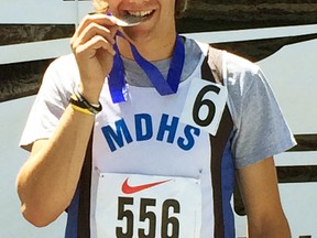 Cody Pauli, of MDHS, takes a bite out of his silver medal he won in the senior boys 400m hurdles at the OFSAA track and field championships in Toronto Saturday, June 6. SUBMITTED PHOTO