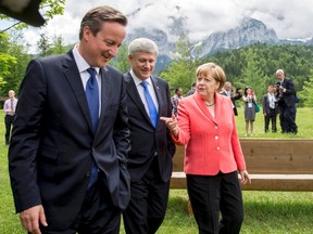 German Chancellor Angela Merkel speaks with British Prime Minister David Cameron (L) and Canadian Prime Minister Stephen Harper outside the Elmau castle in Kruen near Garmisch-Partenkirchen, Germany, June 8, 2015. Leaders of the Group of Seven (G7) industrial nations vowed at a summit in the Bavarian Alps on Sunday to keep sanctions against Russia in place until President Vladimir Putin and Moscow-backed separatists fully implement the terms of a peace deal for Ukraine.          REUTERS/Michael Kappeler/Pool