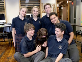 Students from Leahurst College in Kingston, front left, Ryan McIvor and Josh Sequillion; rear from left, Isla Turke, Emily-Kate Taylor, Liam Jones and Noor Mohamed gather around Lawrence, their service dog in training. (Ian MacAlpine /The  Whig-Standard)