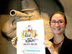 Tricia Knowles, special events manager for the Pam American Games Festival at Fort Henry in July, holds a poster promoting the event in the fort in Kingston. (Michael Lea/The Whig-Standard)