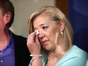 Shelly MacInnis-Wynn wipes a tear as MP Brent Rathgeber introduces Dave Wynn's Law during a news conference in St. Albert on Monday June 8, 2015. The law in honour of RCMP officer Dave Wynn seeks to tighten rules for bail release. (PERRY MAH/Edmonton Sun)