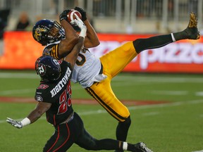 Hamilton Tiger-Cats, Bakari Grant, intercepts a pass for Ottawa RedBlacks, Forrest HighTower at Tim Hortons Field, in Hamilton, Ont. on Monday, June 08, 2015. Dave Thomas/Toronto Sun/Postmedia Network