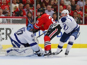 Chicago Blackhawks winger Brandon Saad runs into Tampa Bay Lightning goalie Ben Bishop (30) as centre Steven Stamkos defends during Game 3 of the Stanley Cup final Monday at the United Center in Chicago. (Dennis Wierzbicki/USA TODAY Sports)