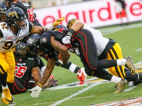 Dan Molls of the Hamilton Tiger-Cats tackles Chevon Walker of the Ottawa RedBlacks at Tim Hortons Field in Hamilton last night. Hamilton led 20-0 at halftime and finished the Canadian Football League pre-season game with a 37-10 victory. (Dave Thomas/Postmedia Network)