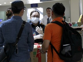 A customs inspector wearing a face mask talks to flight passengers from South Korea upon their arrival at the Ninoy Aquino International Airport in Manila, June 9, 2015. The World Health Organization said on Tuesday that the outbreak of the Middle East Respiratory Syndrome (MERS) in South Korea was the largest seen outside the Middle East, but it should not be a cause of concern. The South Korea's health ministry said on Tuesday there were eight new MERS cases reported, bringing the total of patients to 95.   REUTERS/Romeo Ranoco