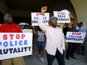 Protestors gesture and hold signs during a protest against what demonstrators call police brutality in McKinney, Texas June 8, 2015. Hundreds marched through the Dallas-area city of McKinney on Monday calling for the firing of police officer Eric Casebolt, seen in a video throwing a bikini-clad teenage girl to the ground and pointing his pistol at other youths at a pool party disturbance. REUTERS/Mike Stone