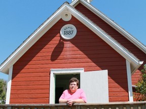 Moore Museum curator Laurie Mason stands in front of a one-room schoolhouse which was originally built in 1887. (File photo)