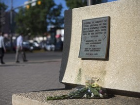 Flowers are pictured below a plaque honouring officers who lost their lives in the line of duty, outside the Edmonton Police Force headquarters June 9, 2015. A police officer, Constable Daniel Woodall, 35, was killed and another officer Sergeant Jason Harley injured on Monday in Edmonton, Canada after an exchange of fire with a suspect, police said. The officers were attempting to arrest the suspect on Monday evening, when the shootings happened, police said. REUTERS/Topher Seguin