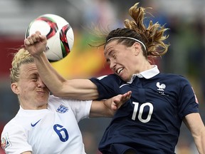 England defender Laura Bassett (left) takes an arm to the face from France’s Camille Abily during Women’s World Cup play at Moncton Stadium June 9, 2015. (AFP PHOTO/FRANCK FIFE)