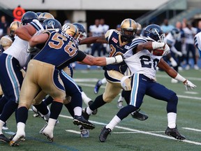 Blue Bombers outside linebacker Thomas Griffiths gets a hold of Argos back Henry Josey during pre-season action at Varsity Stadium on Tuesday night. (Jack Boland/Toronto Sun)