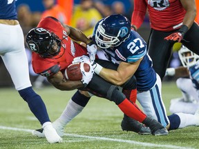 Cory Greenwood of the Argonauts tackles Roy Finch of the Ottawa RedBlacks in the 2014 season finale. (Veronica Henri, Toronto Sun)