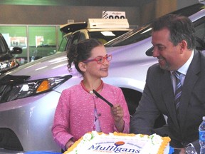 Gabriella Serafini, 7, one of the more than 35,000 patients that benefits from the NEO Kids program at Health Sciences North, cuts cake with Vince Palladino, president of the Palladino Auto Group.