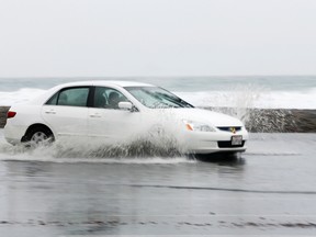 A car makes its way through standing water.

REUTERS/Mike Blake