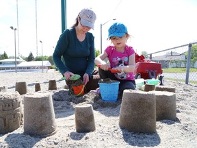 Esrie Niwranski, 4, and her mom, Leah, make sandcastles at the playground at Delki Dozzi Sports Complex in Sudbury, Ont. on Tuesday June 9, 2015. John Lappa/Sudbury Star/Postmedia Network