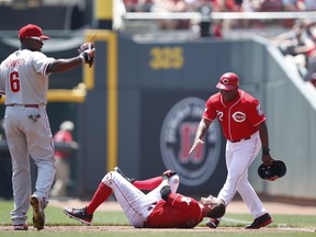 Zack Cozart of the Cincinnati Reds holds his knee after suffering an injury on a play at first base in the first inning against the Philadelphia Phillies at Great American Ball Park on June 10, 2015 in Cincinnati, Ohio.  (Joe Robbins/AFP)