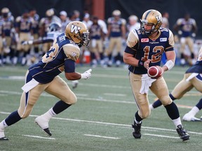 Winnipeg Blue Bombers Brian Brohm, QB (12) hands off to Da’Rel Scott, RB in the first half during CFL pre-season action in Toronto, Ont. at Varsity Stadium on Tuesday June 9, 2015. Jack Boland/Toronto Sun/Postmedia Network
