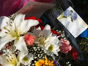 A makeshift memorial of flowers and cards is seen at 18620 62A Avenue in Edmonton, Alta., on Wednesday June 10, 2015. Const. Daniel Woodall was shot and killed executing a warrant at the house on June 8. Edmontonians have responded to the officer's death by laying flowers and signing books of condolence at sites across the city. Ian Kucerak/Edmonton Sun