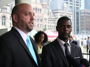 Toronto resident Knia Singh, right, stands with his lawyer, Vilko Zbogar, while addressing the media about his charter challenge against police carding Wednesday, June 10, 2015. (Terry Davidson/Toronto Sun)