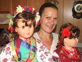 Nadia Luciuk, chair of the Ukrainian pavilion for this weekend's Lviv Ukraine Folklore Festival, holds a couple of dolls at her home in Kingston. The pavilion will showcase the country's culture, music and traditions. (Michael Lea/The Whig-Standard)
