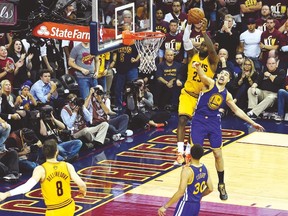Cavaliers’ LeBron James dunks the ball over Warriors guard Klay Thompson on Tuesday night. (USA TODAY SPORTS)