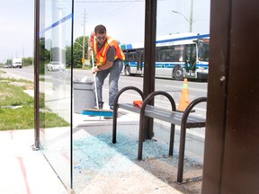 Feris El-Ejel of Lambton Glass and Mirror sweeps broken glass at from an LTC bus shelter on Southdale Rd. at Notre Dame Dr. in London on Thursday. The company has been busy replacing shelter glass during a recent rash of vandalism. Derek Ruttan/The London Free Press/Postmedia Network