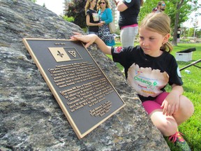 Tatiana Rowe, 8, a Grade 3 student at Les Rapides, a French language public school in Sarnia, looks at a plaque unveiled during a ceremony on the waterfront on Thursday June 11, 2015 in Sarnia, Ont., to commemorate the 400th anniversary of a Francophone presence in Ontario. (Paul Morden, The Observer)