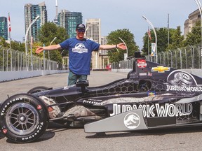 IndyCar driver Scott Dixon shows offhis car’s special new Jurassic World paint scheme on Thursday at Exhibiton Place. (DAVE THOMAS/Toronto Sun)