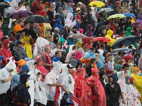 Soccer fans wait in the rain for the start of theTeam Canada and New Zealand FIFA Women's World Cup Canada 2015 game at Commonwealth Stadium, in Edmonton Alta. on Thursday June 11, 2015. David Bloom/Edmonton Sun/Postmedia Network