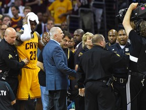 Cavaliers forward LeBron James holds his head after being cut during a collision with a cameraman on Thursday night against the Golden State Warriors. (USA TODAY SPORTS)