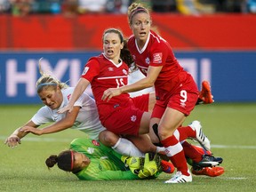 Canada's goalkeeper Erin McLeod makes a save as  New Zealand's Rosie White and Canada's Allysha Chapman, No. 15 and Josée Bélanger, No. 9, fall on her during a FIFA Women's World Cup 2015 match at Commonwealth Stadium. (Ian Kucerak, Edmonton Sun)