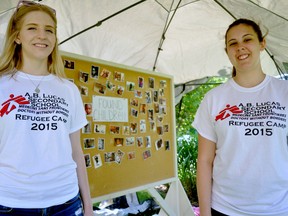 Grade 12 students Allison Stepien (left) and Victoria Kacer stand near a missing children board, part of a mock refugee camp set up at AB Lucas secondary school in London Ont. June 11, 2015. CHRIS MONTANINI\LONDONER\POSTMEDIA NETWORK