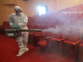 A worker in full protective gear disinfects an art hall in Seoul, South Korea, June 12, 2015. South Korea has sealed off two hospitals that treated people with a deadly respiratory disease, officials said, even as the outbreak that has been spreading through health facilities could have peaked, with just four new cases on Friday.  REUTERS/Seo Myeong-gon/Yonhap