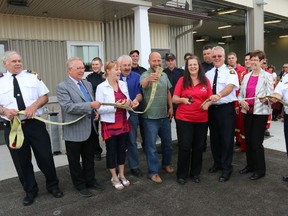 Members of Prince Edward County’s fire department, staff and council help fire chief Scott Manlow (centre front, white shirt) cut a fire hose to signal the grand opening of the new 5,500 square foot Consecon Fire Hall on Thursday evening.
Bruce Bell/The Intelligencer/Postmedia Network
