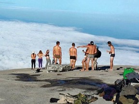 Tourists gather before stripping on Mount Kinabalu. Two Saskatchewan siblings have been barred from leaving Malaysia for allegedly stripping for photos on a sacred mountain last week in an act an official there believes triggered a deadly earthquake and landslides. Kinabalu Park/Handout/Postmedia Network