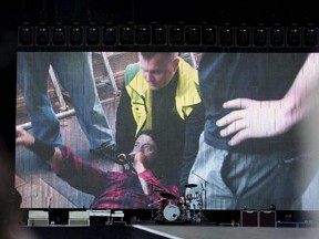Foo Fighters band member Dave Grohl is seen on a big screen talking on a microphone after falling from the stage during the band's concert at Nya Ullevi in Gothenburg, Sweden, June 12, 2015. REUTERS/Erik Abel/TT News Agency