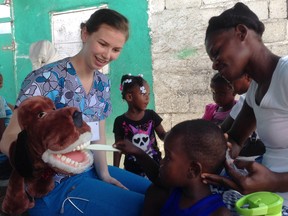 Lambton College nursing student Kendra Steadman helps teach dental hygiene to children at the Shada Clinic in Cap-Haitian. She and close to 30 other students went on one of two trips to Haiti earlier this year as part of their curriculum. Toothbrushes, toothpaste, and the puppet were donated from local dentist Dr. Mark Cornelious. (Handout)