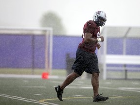 Michael Sam, newly signed defensive end for the Montreal Alouettes CFL football team runs off the field as rain falls during rookie training camp in Sherbrooke, Quebec May 27, 2015. (REUTERS/Christinne Muschi)