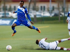 FC Edmonton Lance Laing (left) collides with Vancouver Whitecaps Ethen Sampson during Game 2 of the Amway Canadian Championship semifinal at Clarke Stadium in Edmonton, Alta., on Wednesday May 20, 2015. Ian Kucerak/Edmonton Sun/Postmedia Network