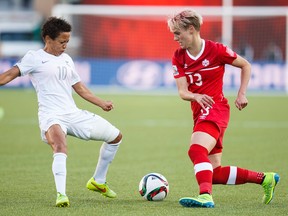 Canada's Sophie Schmidt dekes around New Zealand's Sarah Gregorius during Thursday's game at Commonwealth Stadium. (Ian Kucerak, Edmonton Sun)