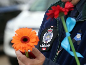People hold flowers during a prayer walk organized by Our Saviour Lutheran Church in Edmonton , Alberta on Friday June 12, 2015. The walk included several churches and honoured  fallen police officer Daniel Woodall.(PERRY MAH/Edmonton Sun/Postmedia Network)