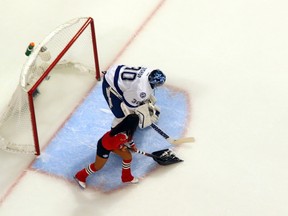 Ben Bishop of the Tampa Bay Lightning stays in position as a member of the ice crew tries to clear the crease during Game 3 of the Stanley Cup Final against the Chicago Blackhawks at the United Center on June 8, 2015. (Bruce Bennett/Getty Images/AFP)