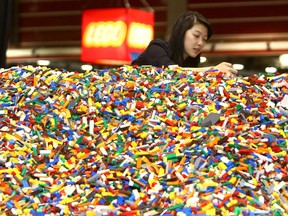 Kim Tran, Brick Specialist for LEGO Brand Retail, has some fun setting up displays for the LEGO Kidsfest North American tour in Calgary, Alta., on May 15, 2014. (Darren Makowichuk/Postmedia Network Files)