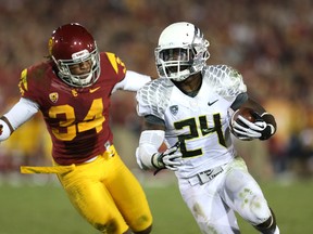 Running back Kenjon Barner #24 of the Oregon Ducks carries the ball against linebacker Tony Burnett #34 of the USC Trojans in the third quarter at the Los Angeles Memorial Coliseum on November 3, 2012 in Los Angeles, California. Burnett is now trying to crack the roster of the Winnipeg Blue Bombers.