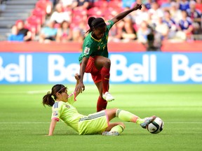 Jun 12, 2015; Vancouver, British Columbia, CAN; Cameroon defender Yvonne Leuko (4) attempts to avoid Japan midfielder Nahomi Kawasumi (9) during the first half in a Group C soccer match in the 2015 FIFA women's World Cup at BC Place Stadium. Mandatory Credit: Anne-Marie Sorvin-USA TODAY Sports